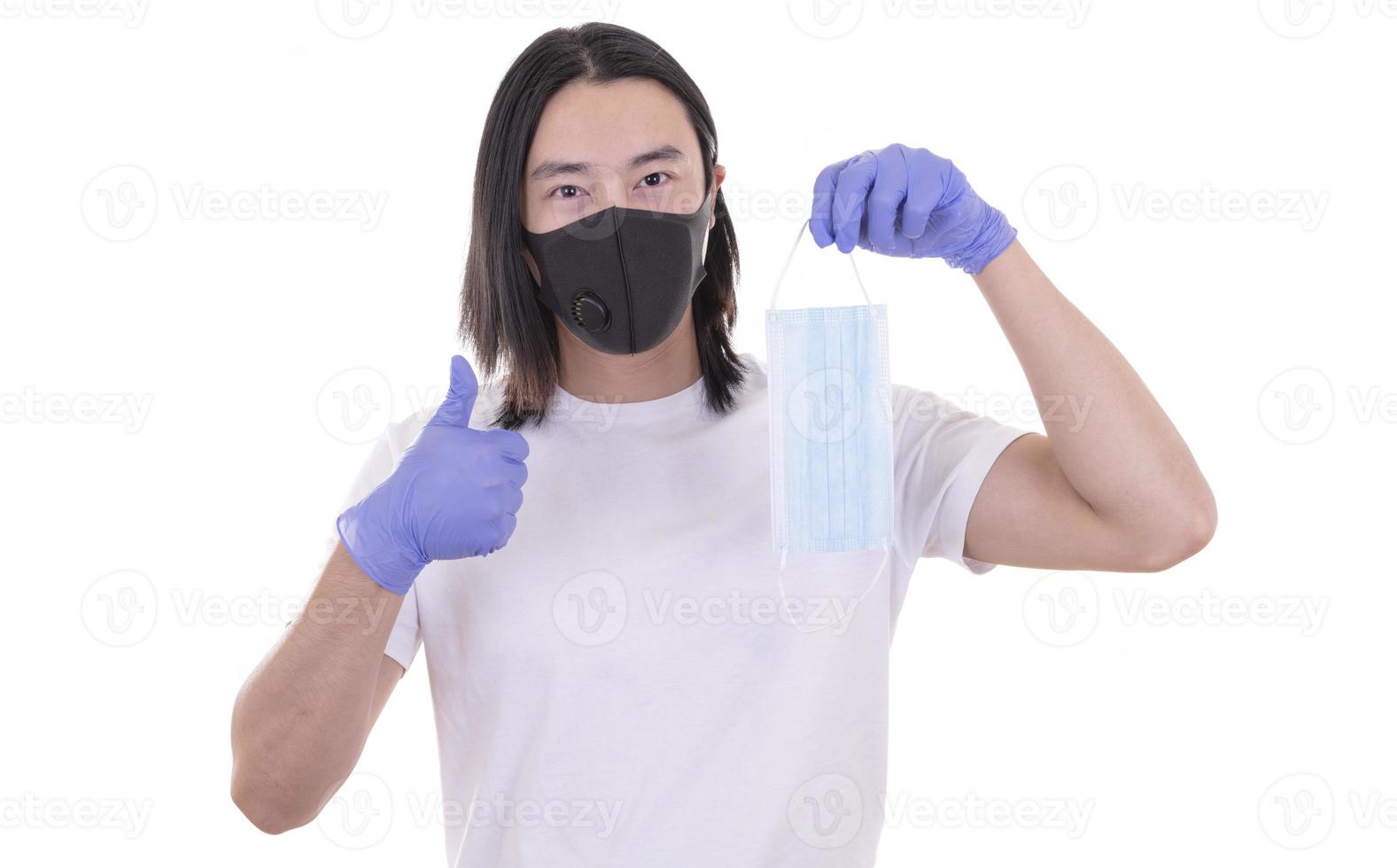 Asian male model wearing and holding surgical face mask and protective gloves photo