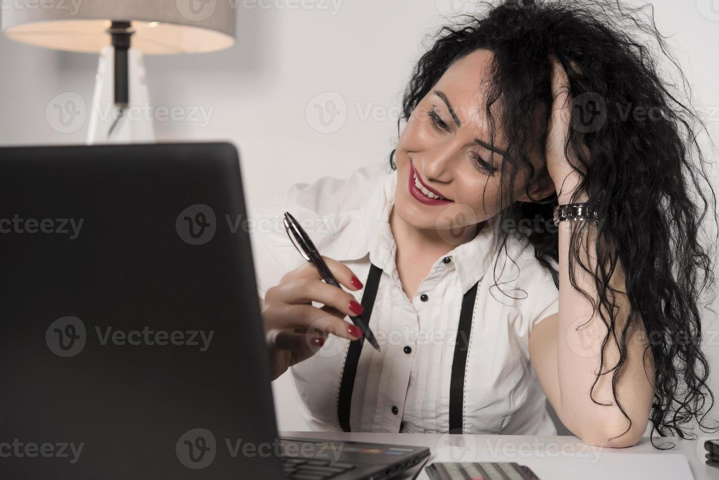 happy business woman trying to work in her office photo