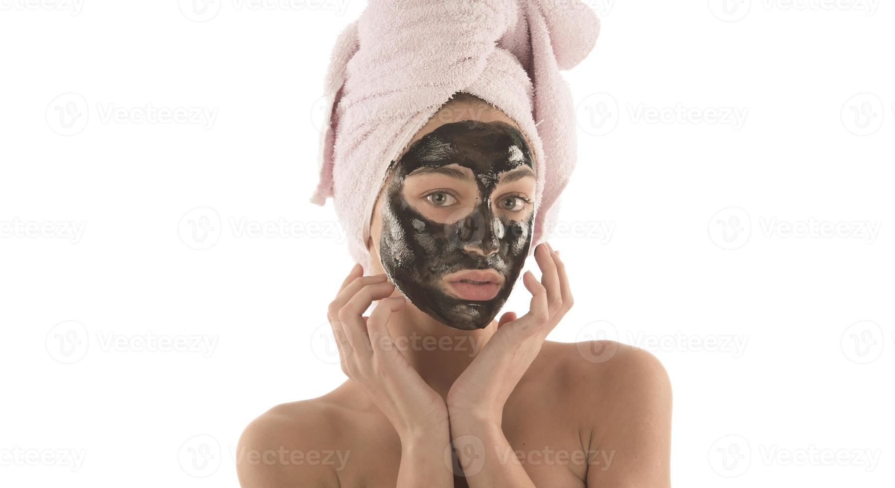 Beautiful girl with black facial cosmetic mask. Beauty concept. isolated photo