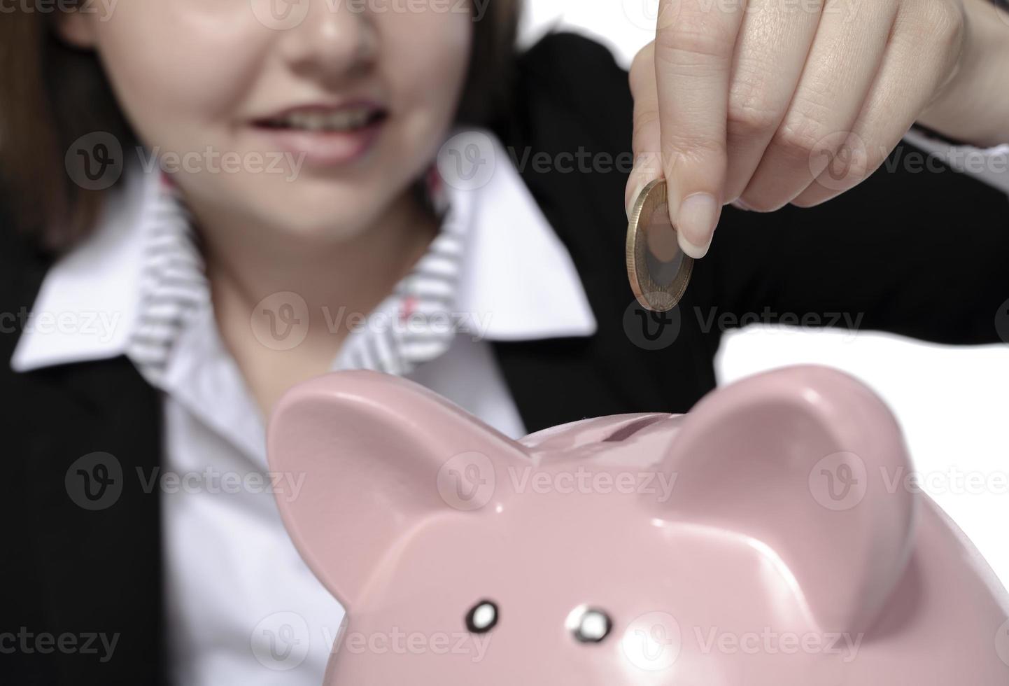 saving concept. beautiful female model saving her money in a piggy bank photo