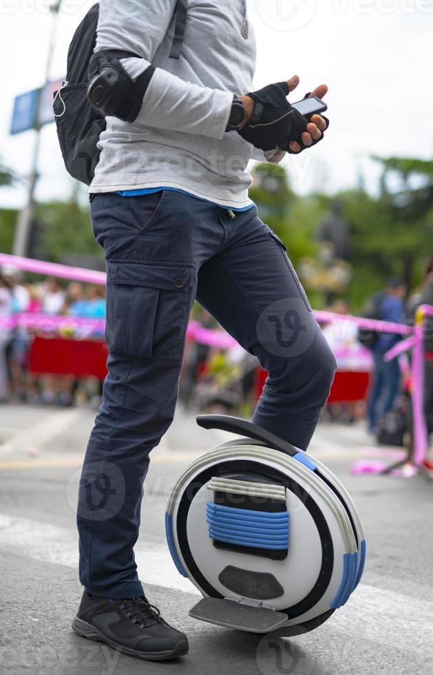 Electric unicycle. Man rides on mono wheel on zebra crossing photo