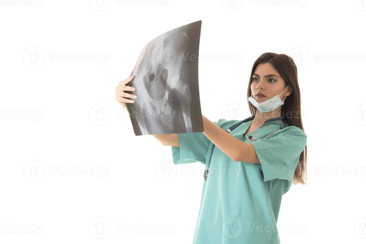 joven doctora mirando la imagen de rayos x. aislado en blanco foto