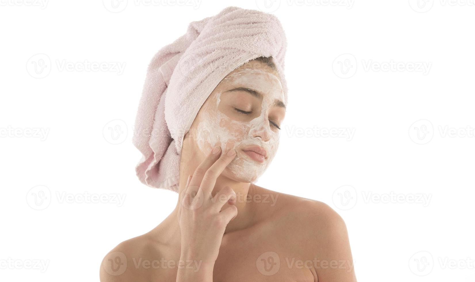 Beauty procedures skin care concept. Young woman applying facial mud clay mask to her face photo