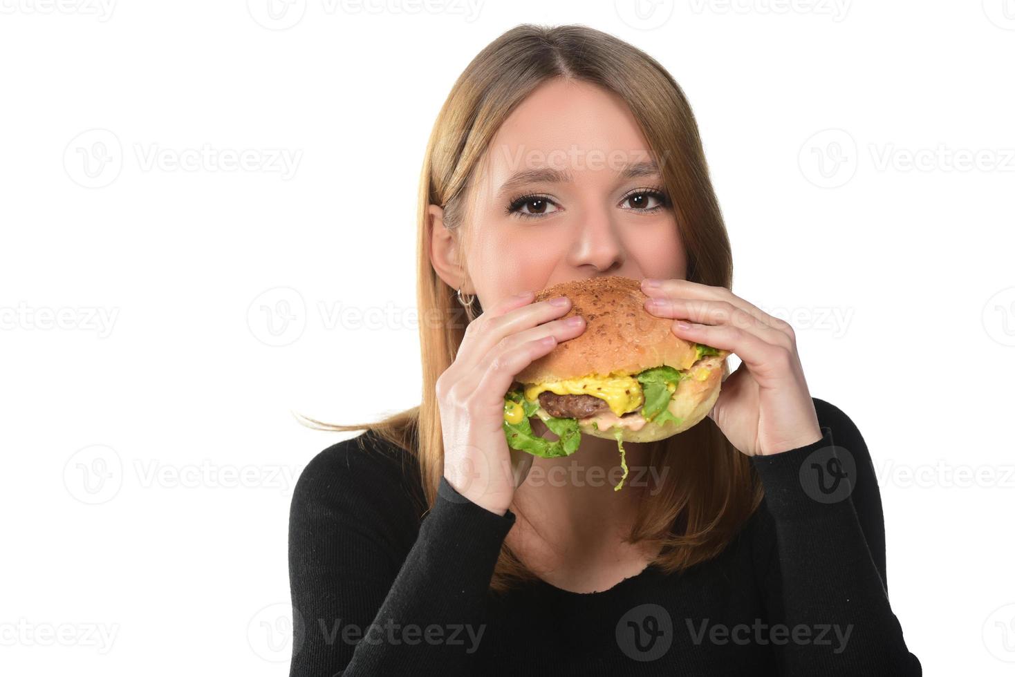 retrato de una hermosa joven divertida comiendo hamburguesa foto