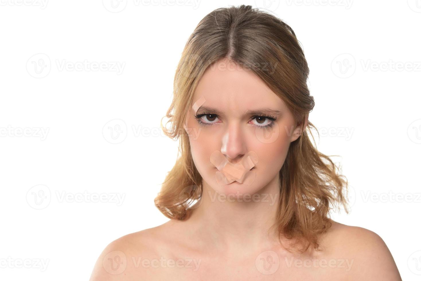 scared young woman with tape over her mouth. photo