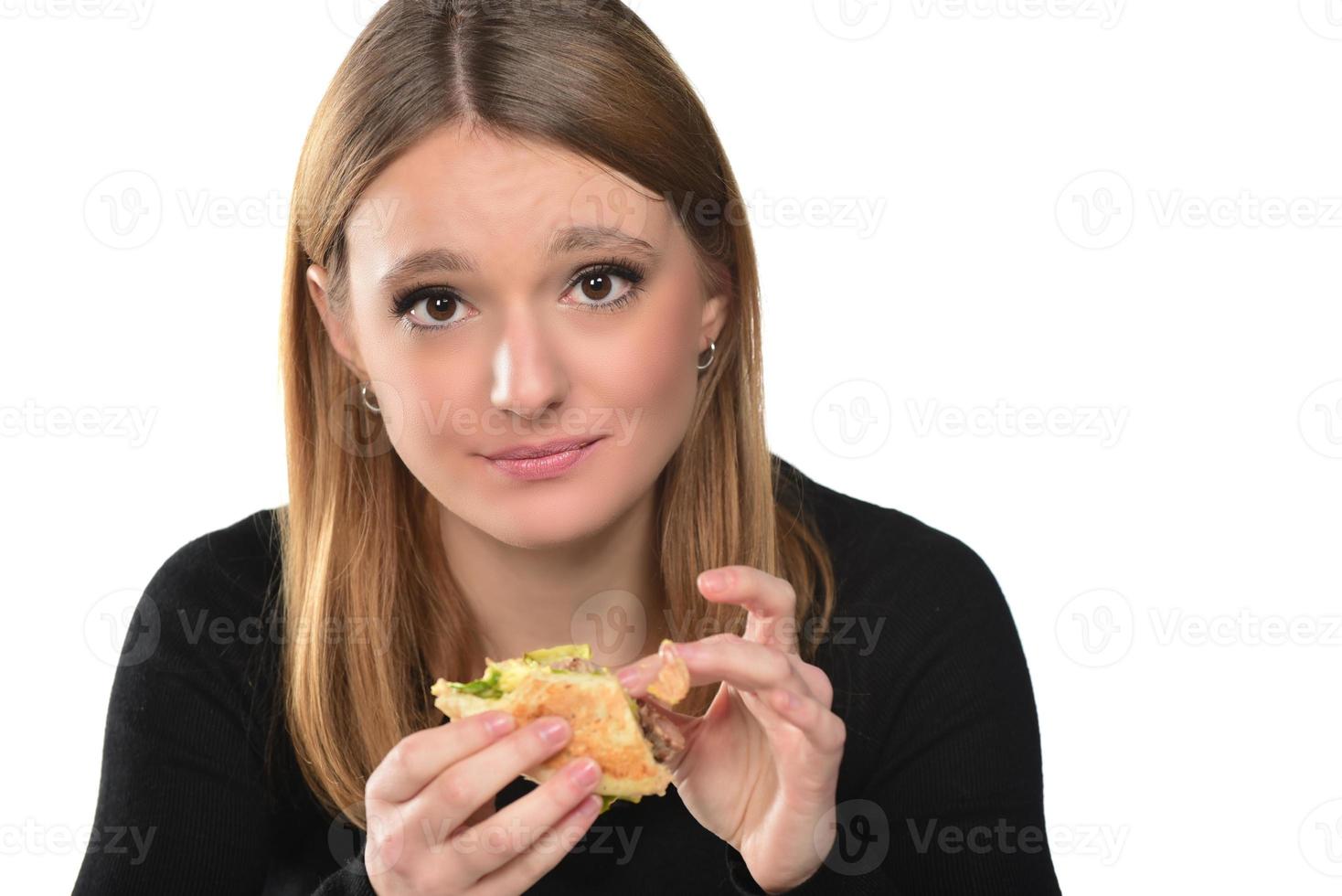 retrato de una hermosa joven divertida comiendo hamburguesa foto