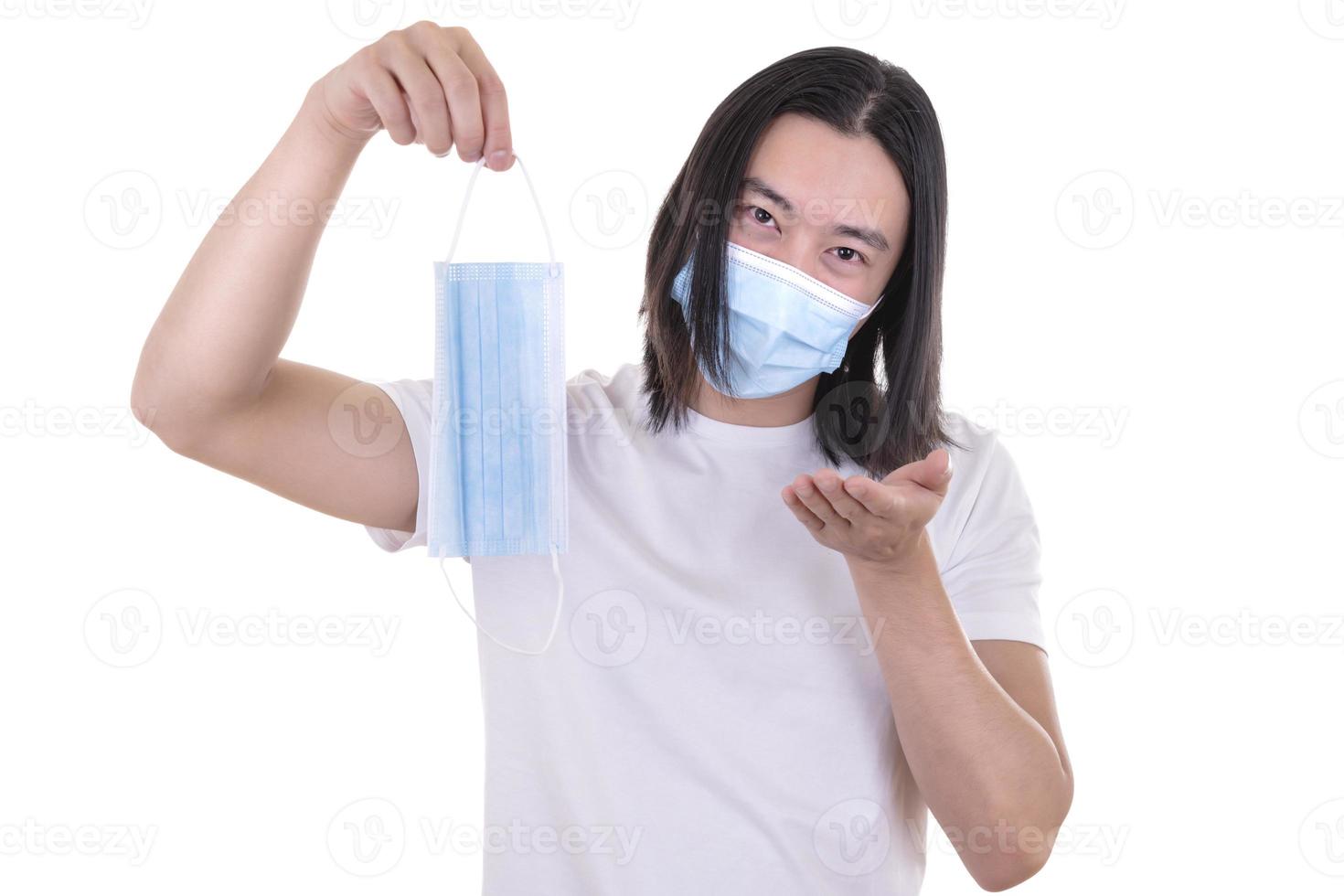 Asian male model wearing and holding surgical face mask and protective gloves photo