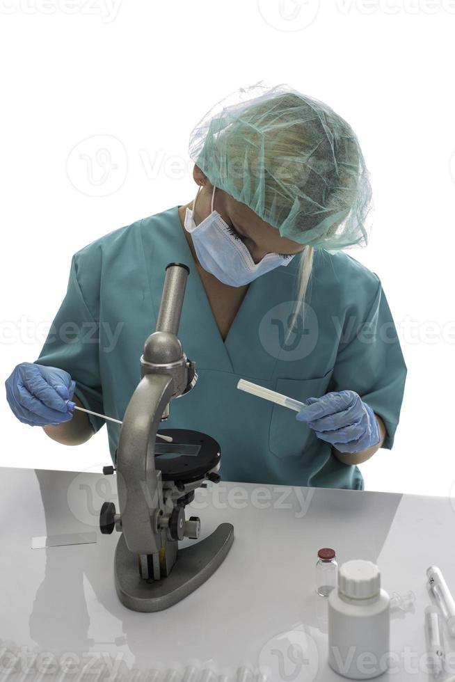 Scientist in blue medical gloves and uniform learning COVID-19 samples with microscope in laboratory. photo