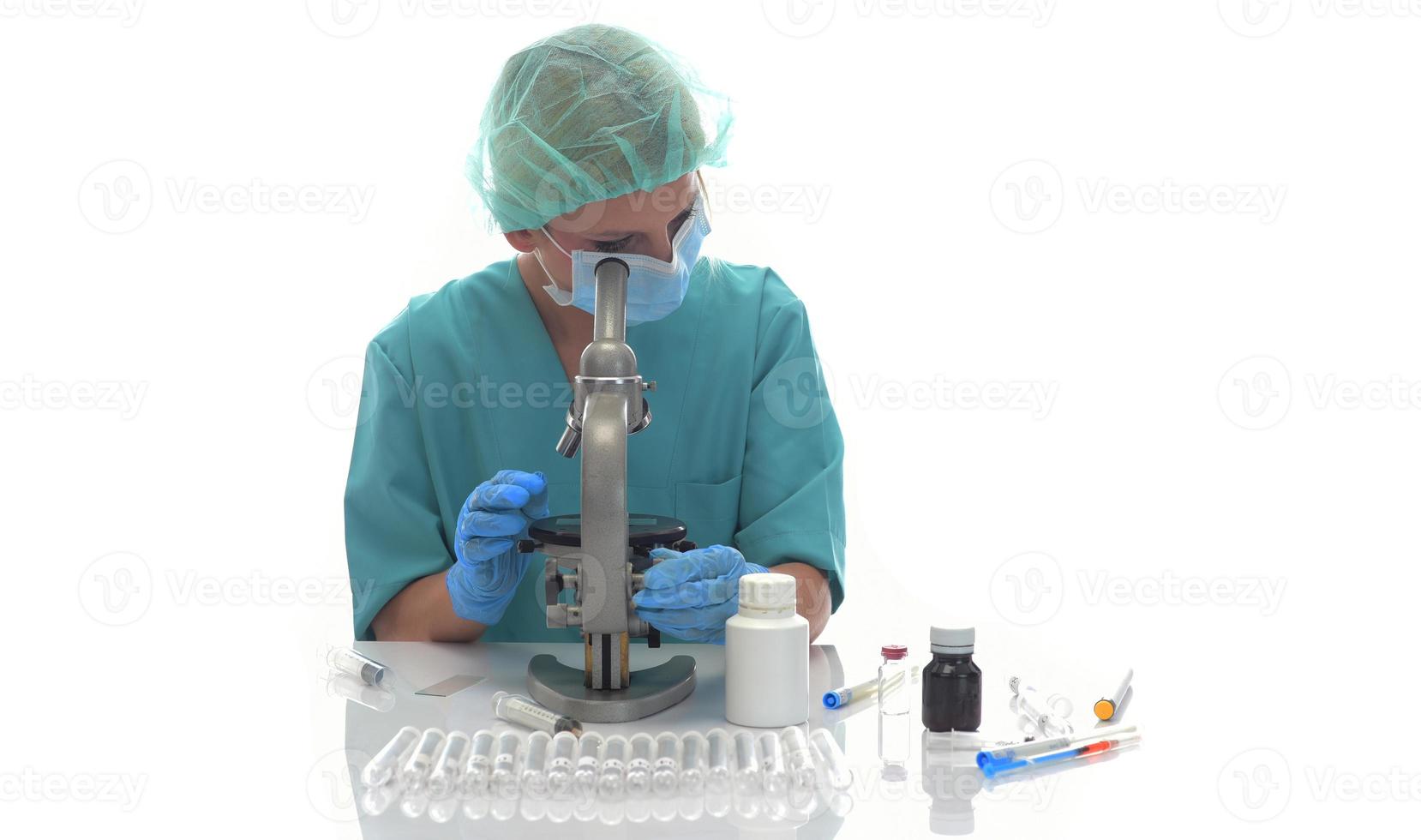 científico con guantes médicos azules y muestras uniformes de aprendizaje covid-19 con microscopio en laboratorio. foto