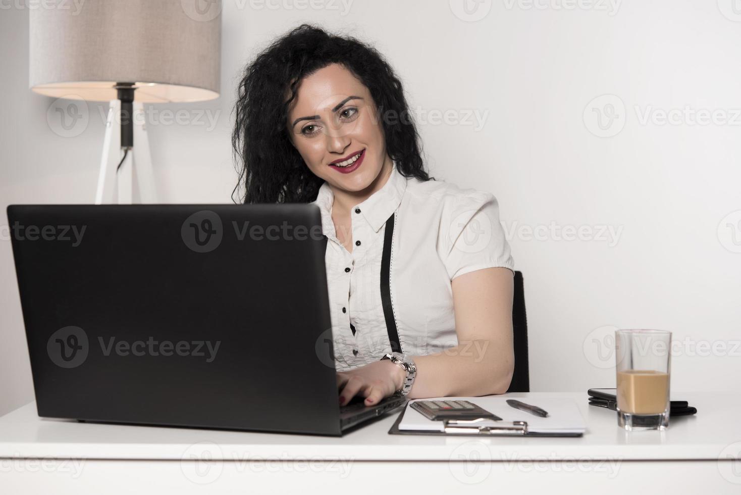 happy business woman trying to work in her office photo