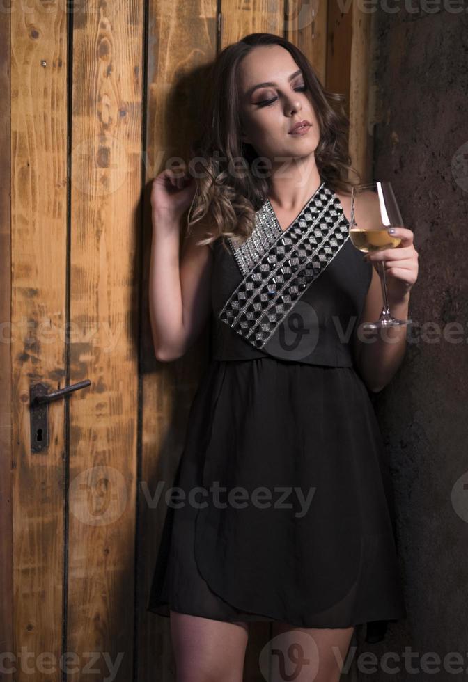 modelo de moda femenina sosteniendo una copa de vino. mujer bebiendo vino. foto