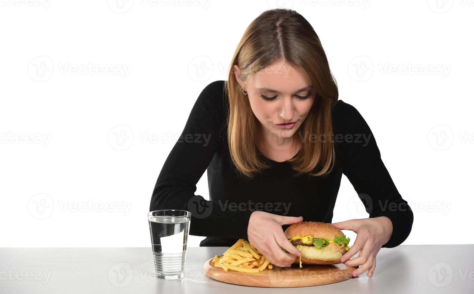 retrato de una hermosa joven divertida comiendo hamburguesa foto