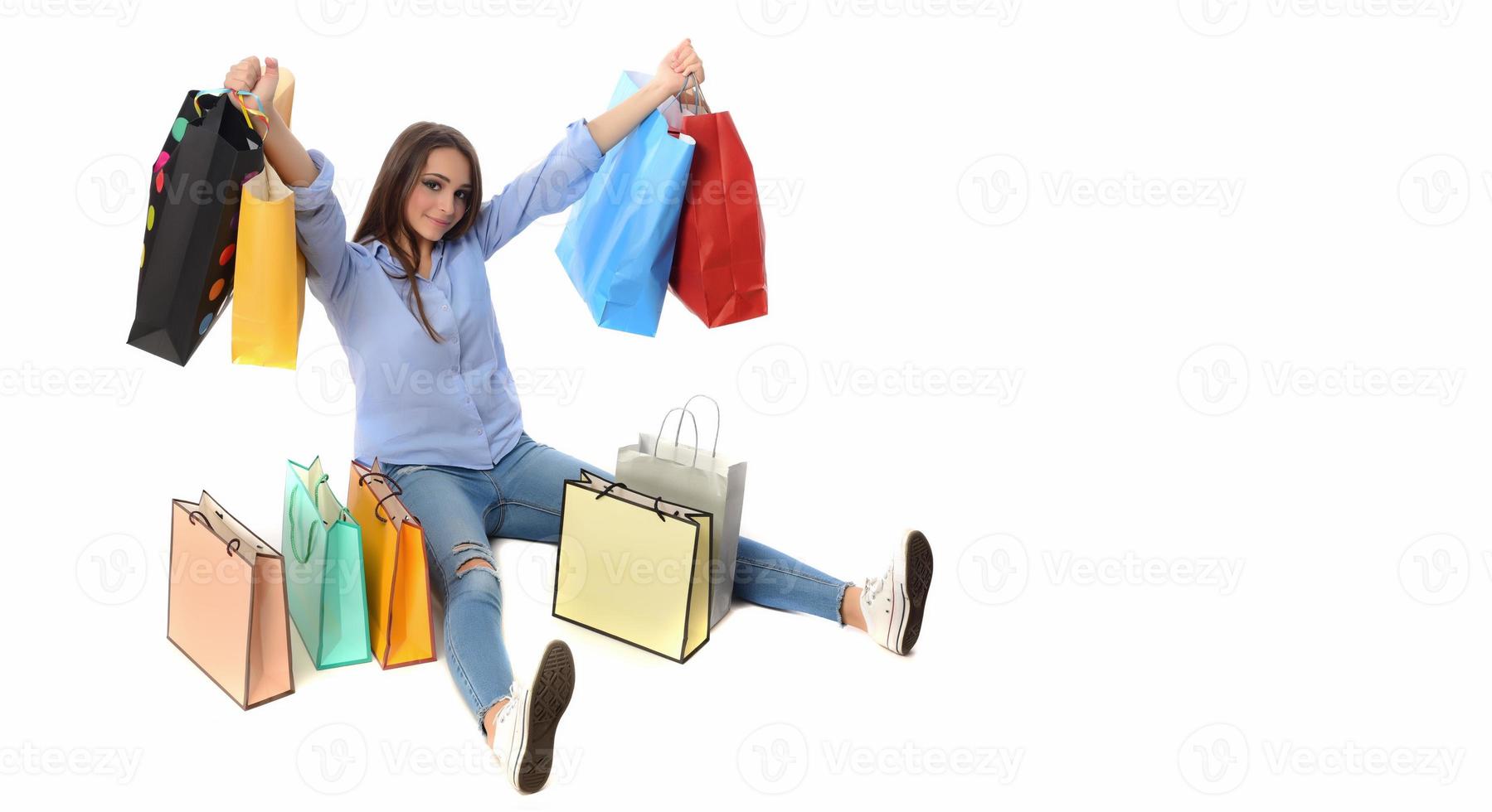 Shopping concept. Beautiful smiling brunette with shopping bags posing on white background photo