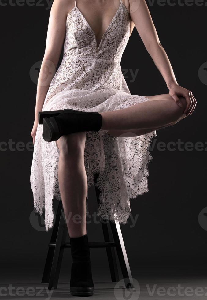 Beautiful blond woman wearing white nightgown posing on black  background. photo