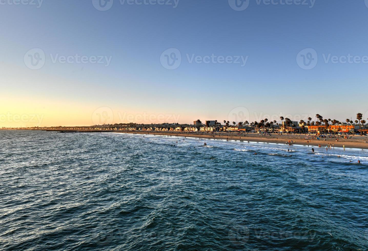 Waves in the Pacific Ocean and view of the beach at sunset, in Newport Beach, California. photo