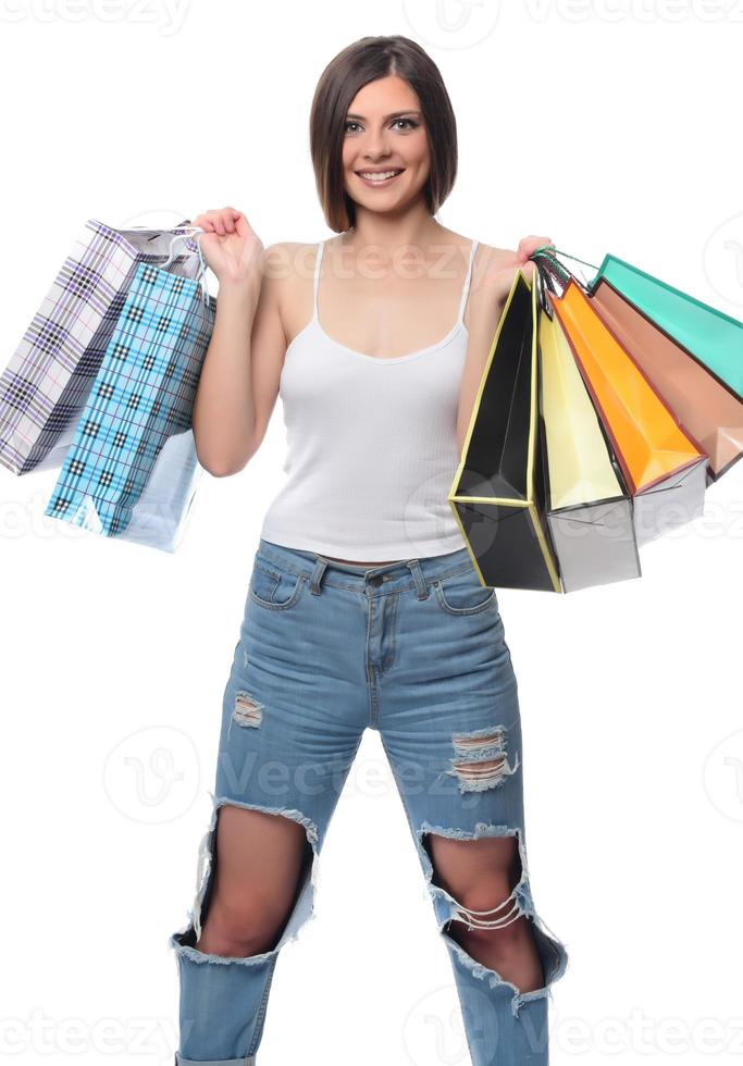 imagen de una hermosa joven morena posando con bolsas de compras y mirando a la cámara. concepto de compras. aislado foto