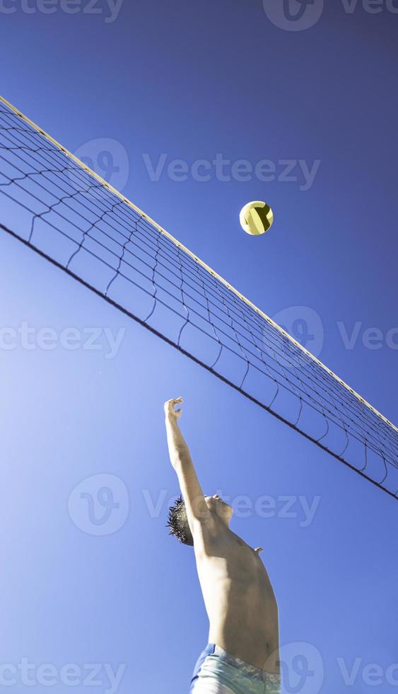 niño juega voleibol en un hermoso día de verano foto