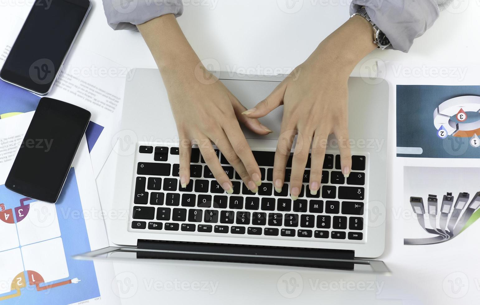 manos escribiendo en una computadora portátil en un escritorio de oficina. concepto de negocio foto