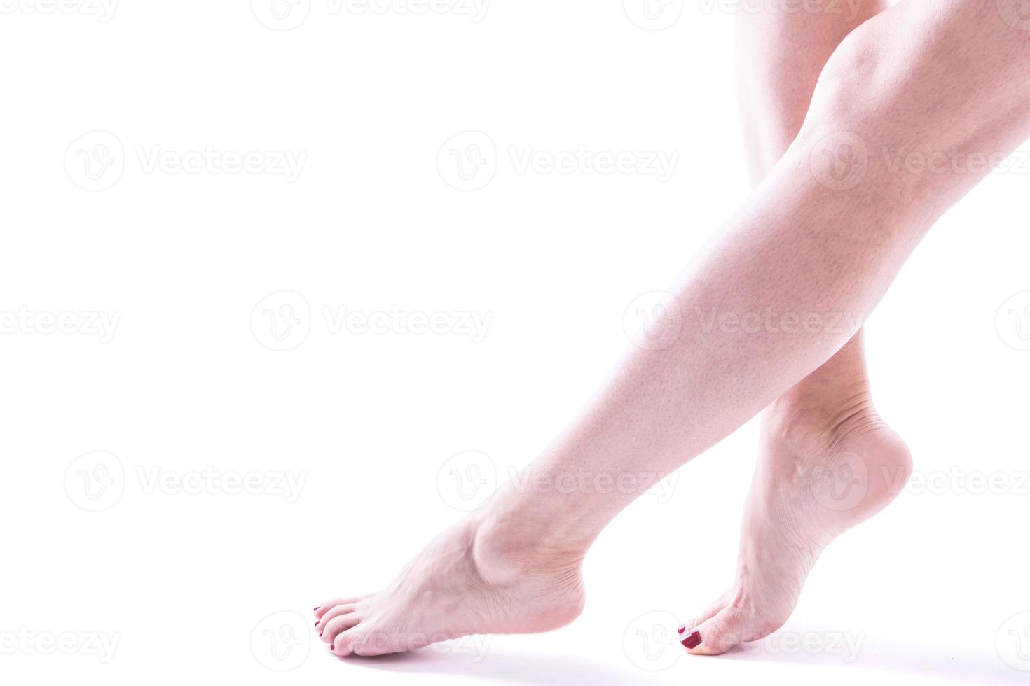 piernas femeninas bellamente arregladas sobre un fondo blanco foto