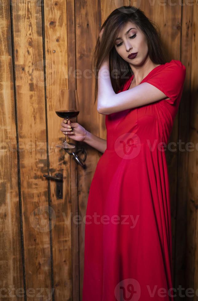 modelo de moda femenina sosteniendo una copa de vino. mujer bebiendo vino. foto