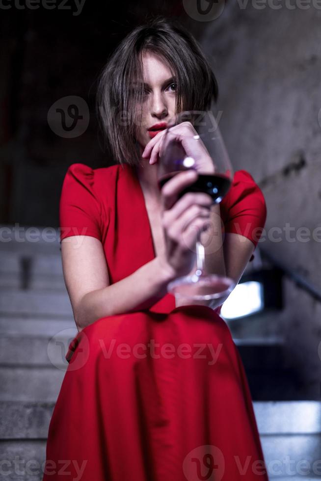 female fashionable model holding glass and bottle of wine. Woman driking wine. photo
