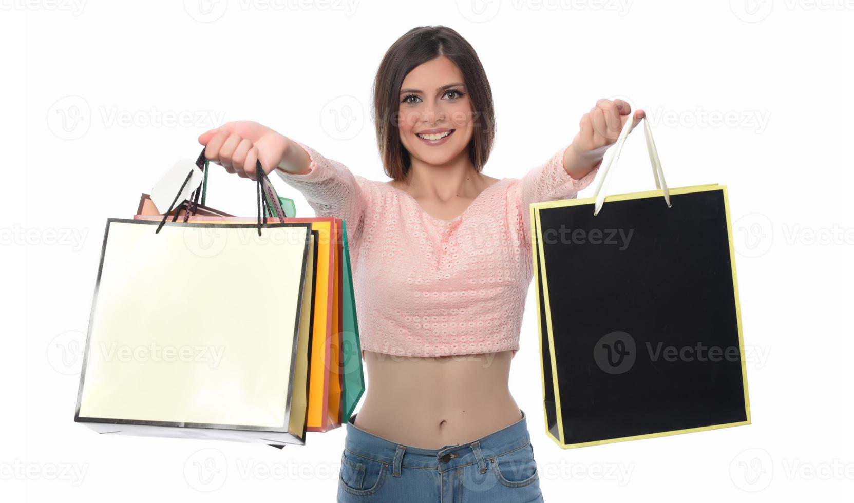 Image of a beautiful young brunette lady posing with shopping bags and looking at camera. shopping concept. Isolated photo