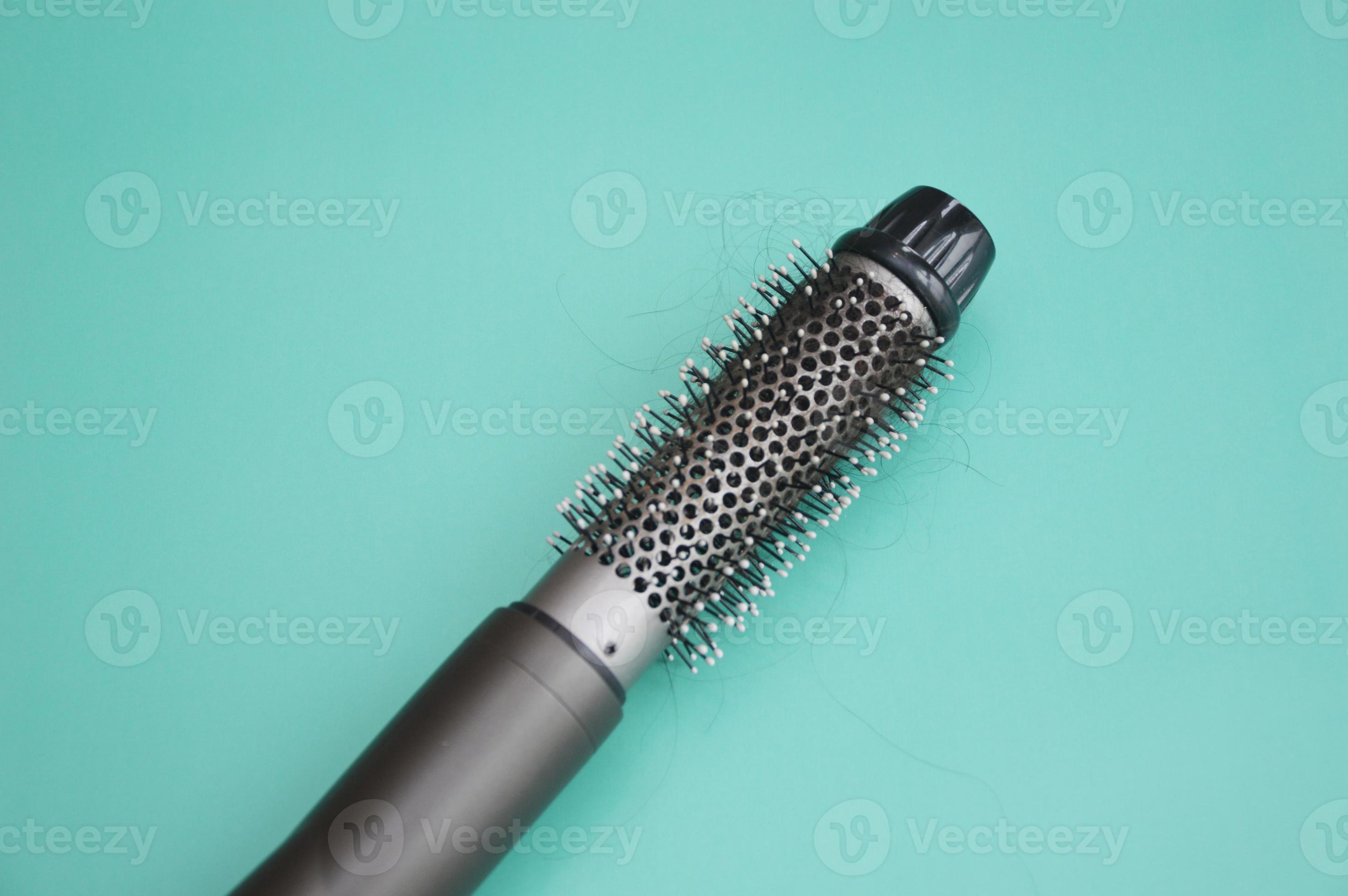 Electric hair dryer with a round brush. Coiled hair after drying. Hair