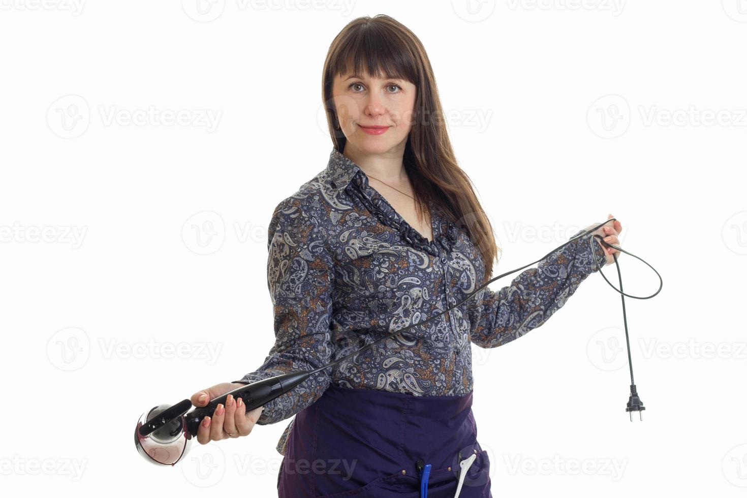 Cheerful brunette woman stylist with hairdryer in studio photo