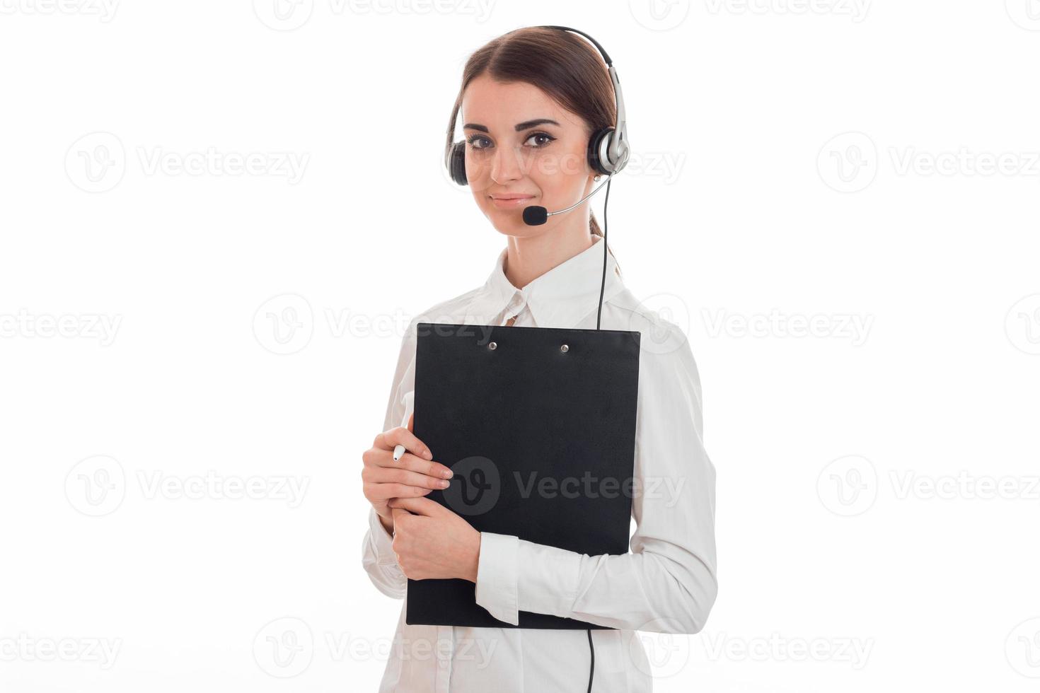 a young girl stands in the headphones with a microphone and holding a black Tablet paper photo