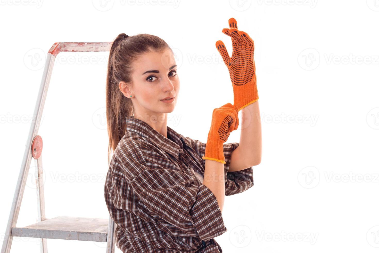 young beauty woman with dark hair in uniforl makes renovations with tools in her hands isolated on white background photo