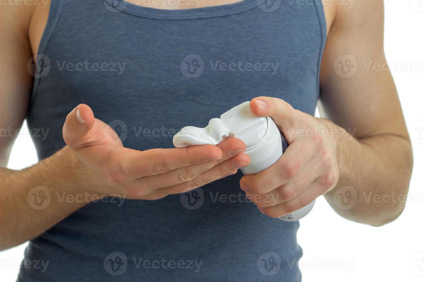 young guy strikes shaving foam on hand close-up photo