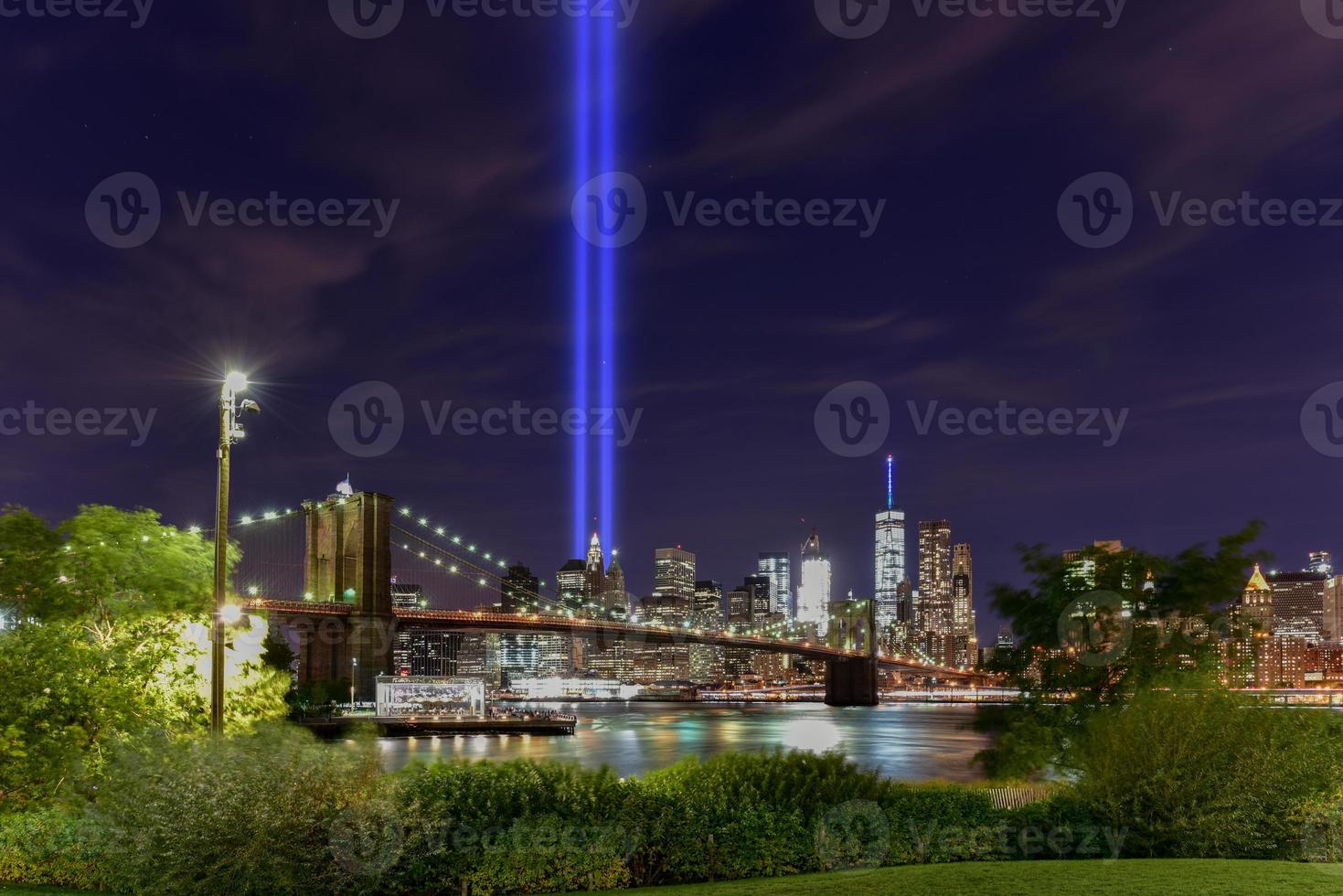 el horizonte del centro de manhattan de la ciudad de nueva york por la noche desde el puente de brooklyn con el tributo a la luz en memoria del 11 de septiembre. foto