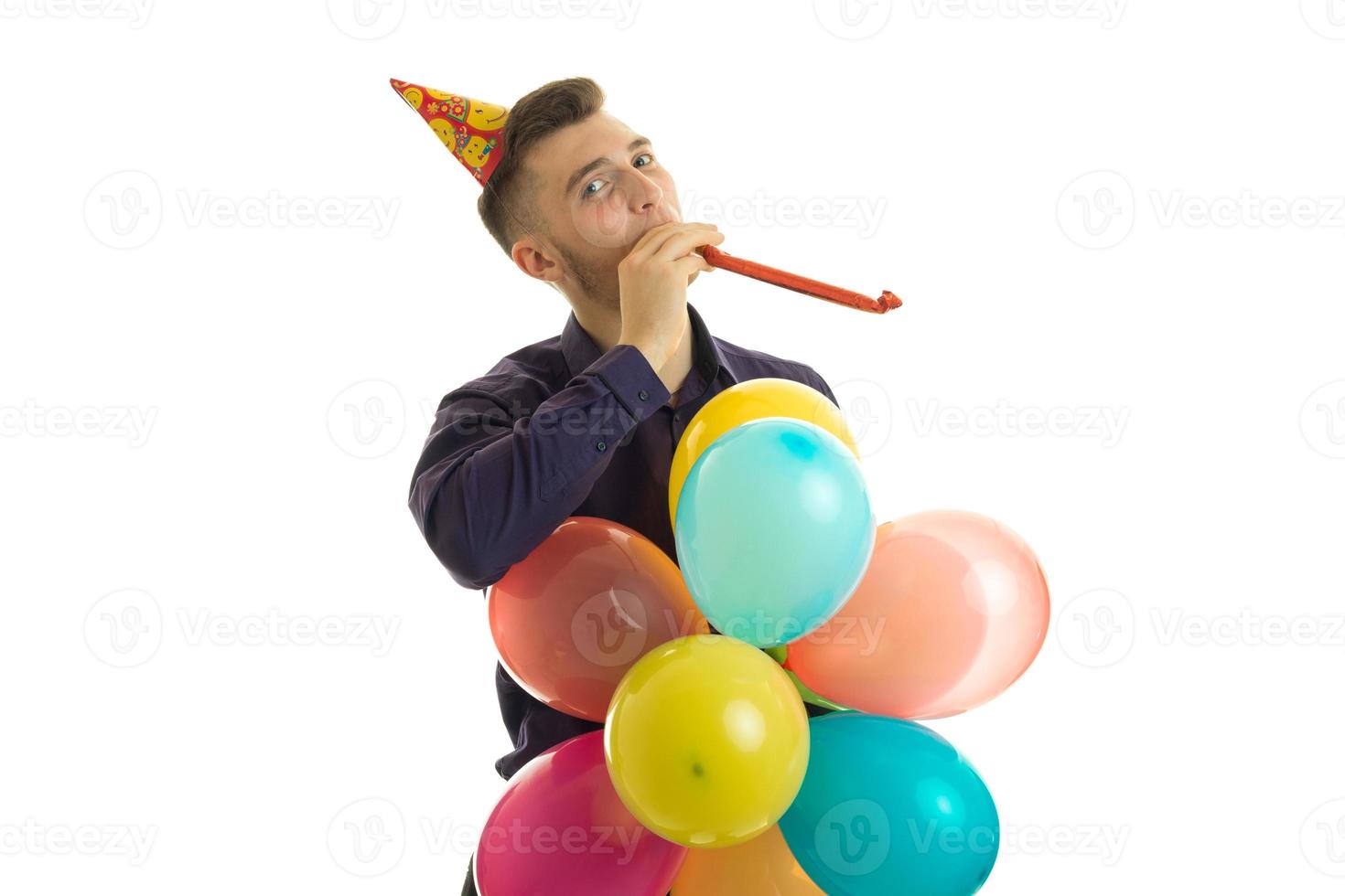 young cute guy looking in the direction of blowing and keeps lots of multicolored balls in hand photo