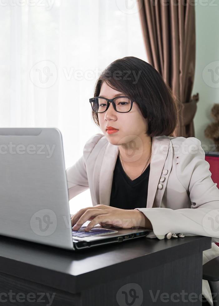 Woman working on laptop in home office photo