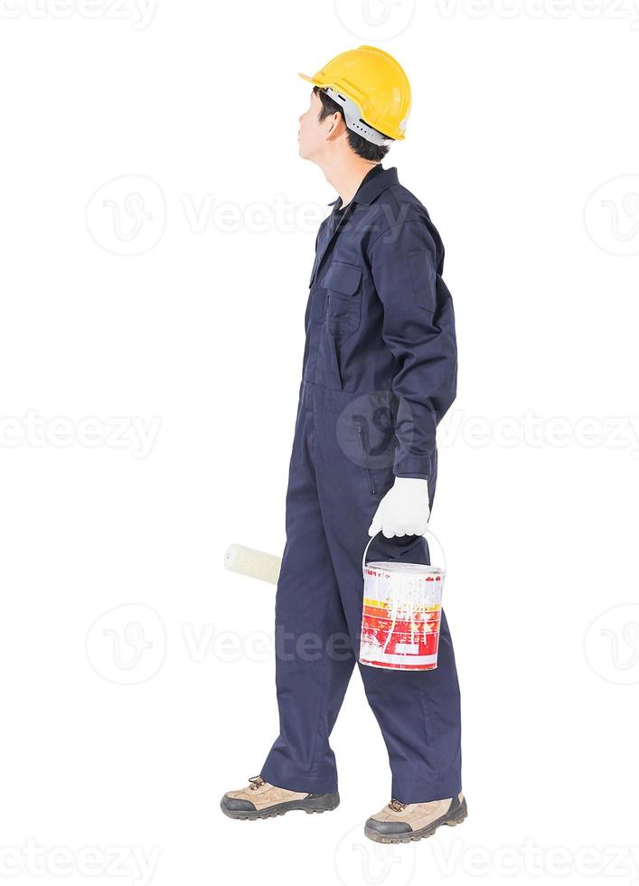 Worker in uniform using paint roller is painting invisible wall photo