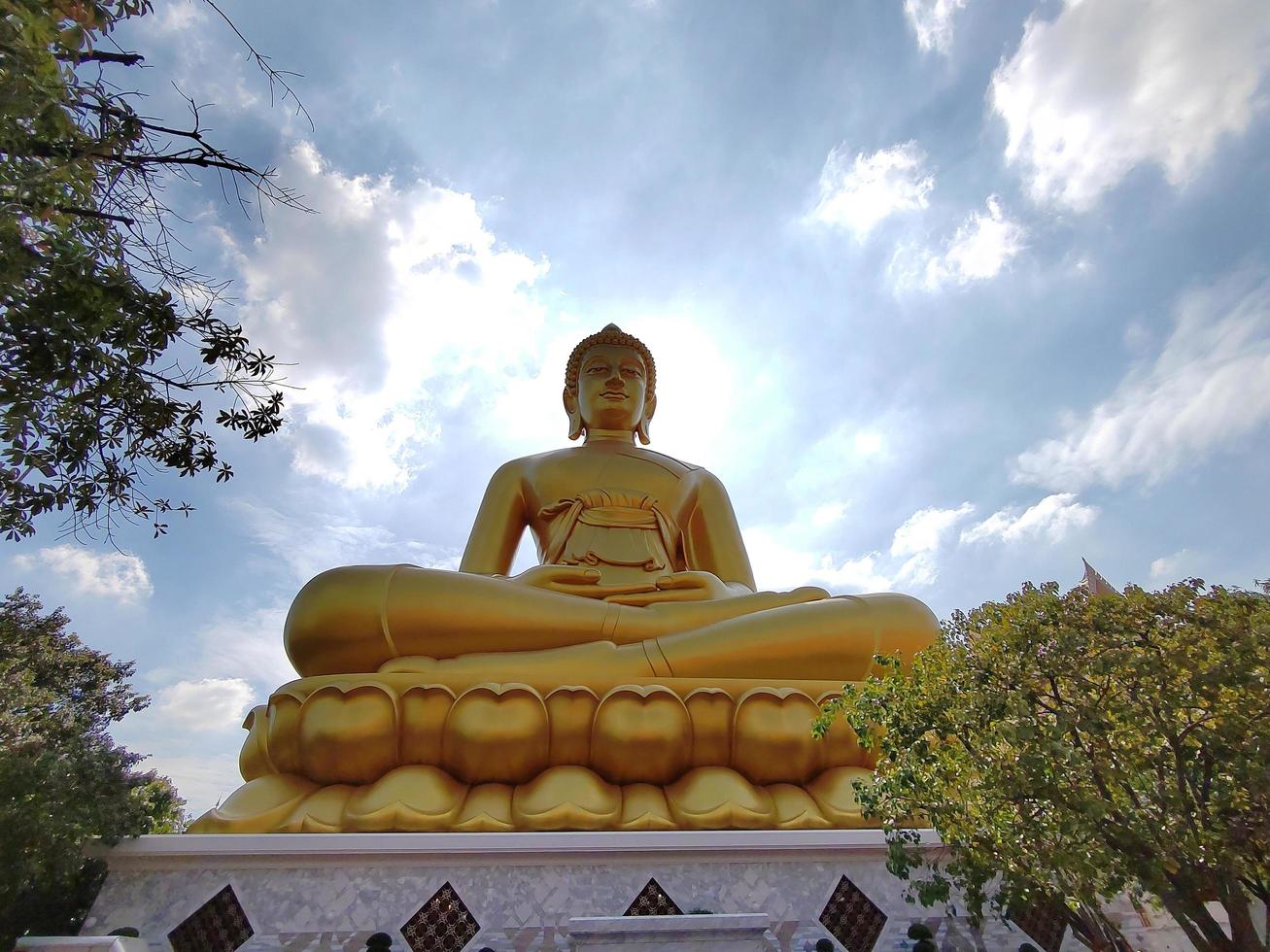 Golden big Buddha statue Phra Buddha Dhammakaya Thep Mongkol in Wat Pak Nam Phasi Charoen temple. Sunlight sky and cloud background photo