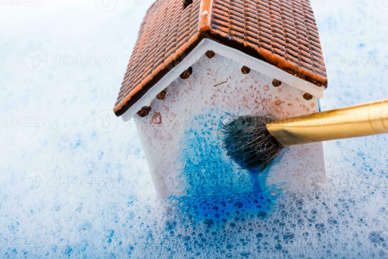 casa modelo y pincel de pintura en agua espumosa foto