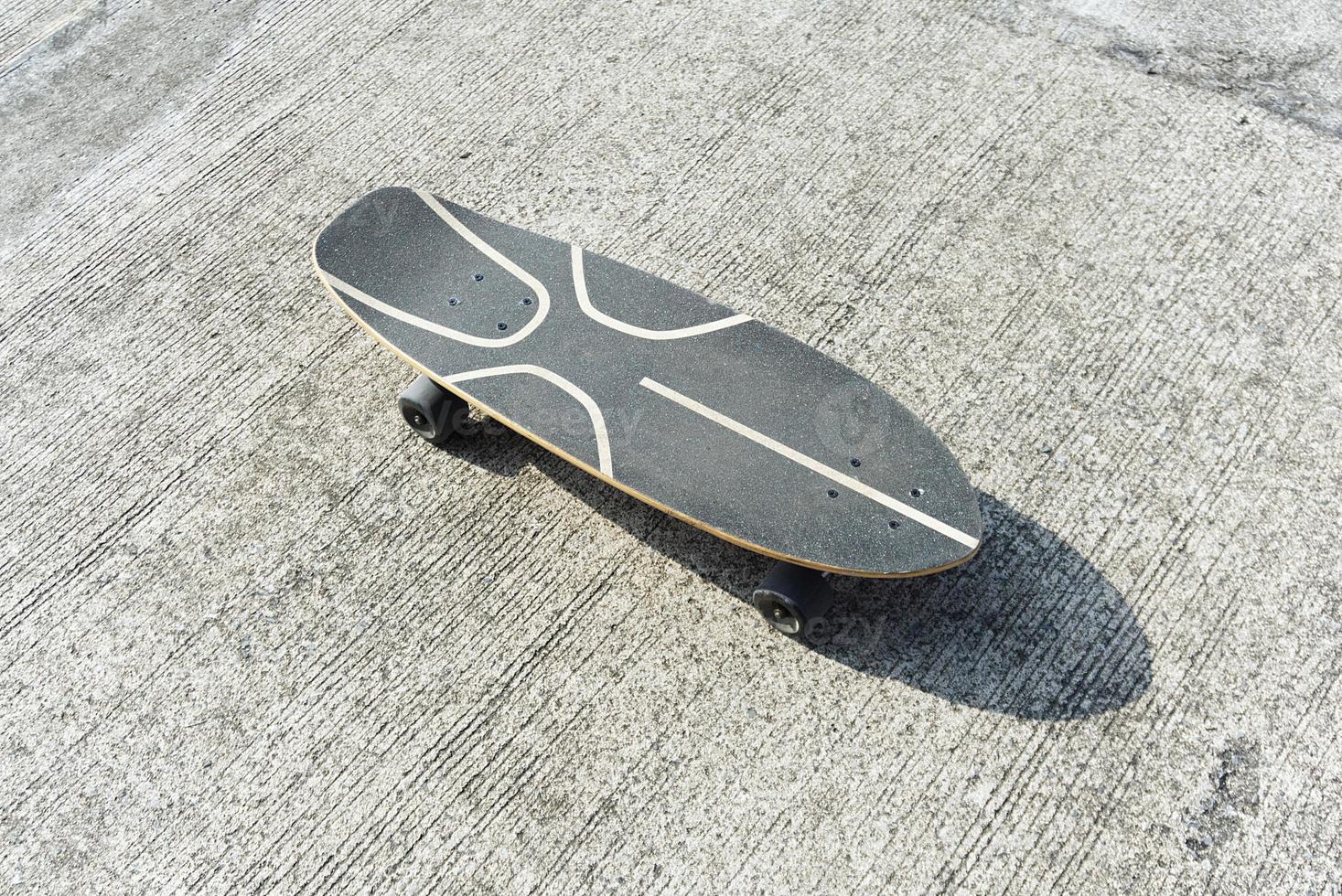 surfskate or skateboard top veiw on concrete road with shadow photo