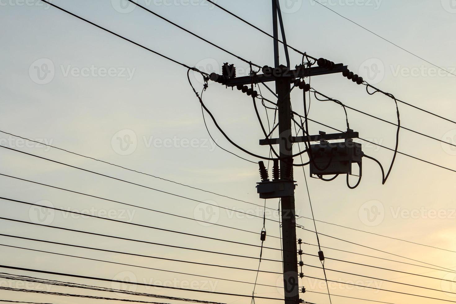 El poste de energía de voltaje medio del consumidor es la gente que usa energía y la pequeña industria en el ambiente cálido y romántico del cielo nocturno. foto