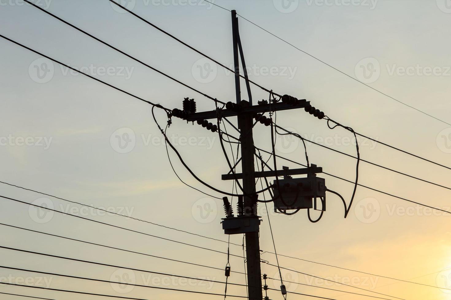 El poste de energía de voltaje medio del consumidor es la gente que usa energía y la pequeña industria en el ambiente cálido y romántico del cielo nocturno. foto