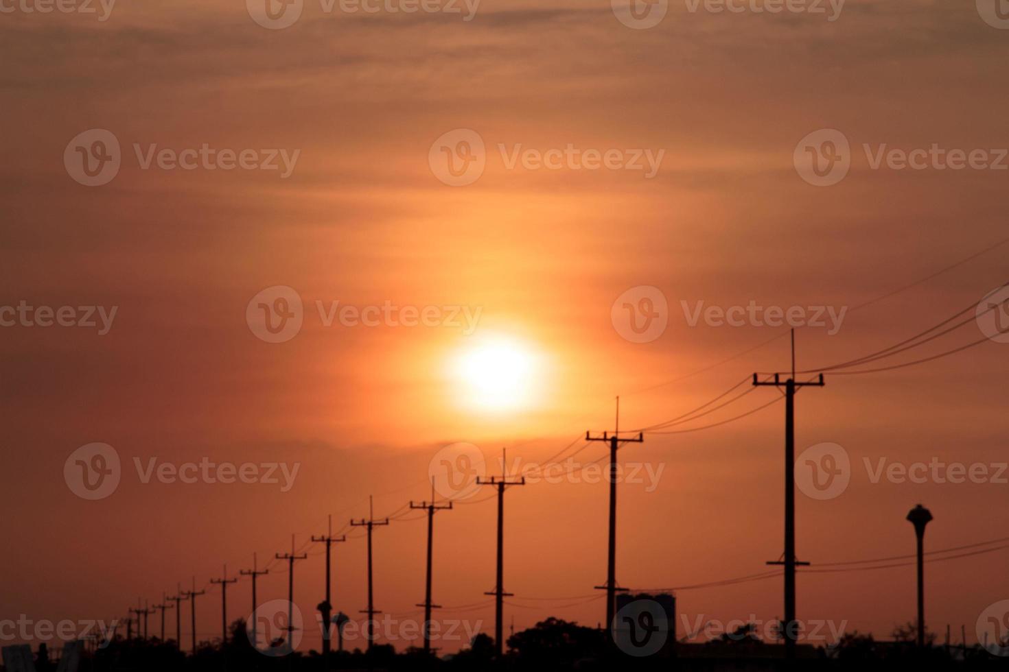 atmosphere in the evening-high voltage pole beside highway and orange sky The big sun that was setting was beautiful as I was on my way home, it was a beautiful romantic atmosphere. photo