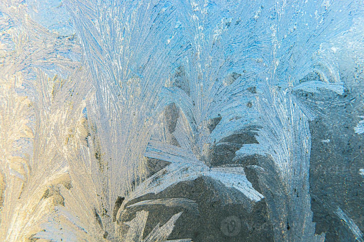 Frozen winter window with shiny ice frost pattern texture. Christmas wonder symbol, abstract background. Extreme north low temperature, natural Ice snow on frosty glass, cool winter weather outdoor. photo