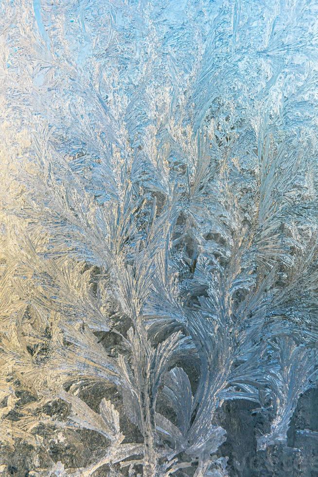 Frozen winter window with shiny ice frost pattern texture. Christmas wonder symbol, abstract background. Extreme north low temperature, natural Ice snow on frosty glass, cool winter weather outdoor. photo