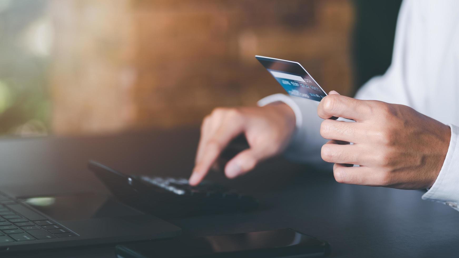Businessman calculating interest rates of credit cards, banking and online shopping, wireless banking, online shopping, consumer social photo