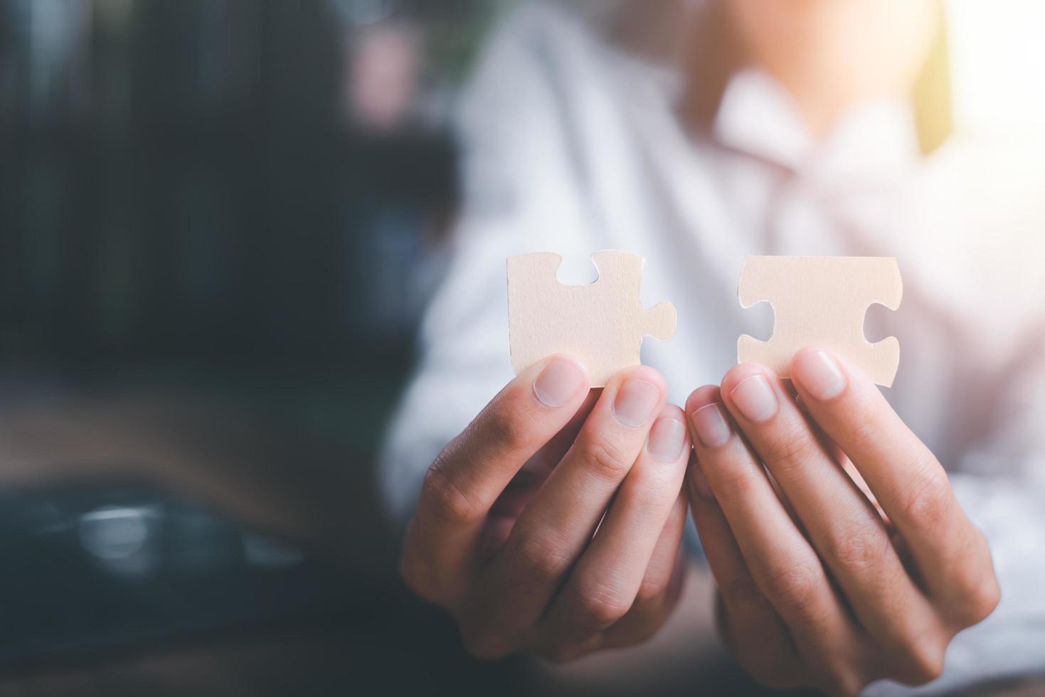 Businessman holding a puzzle piece to find a business solution,Connecting success and problem solution, from creativity,and strategic planning to develop the organization into the future photo