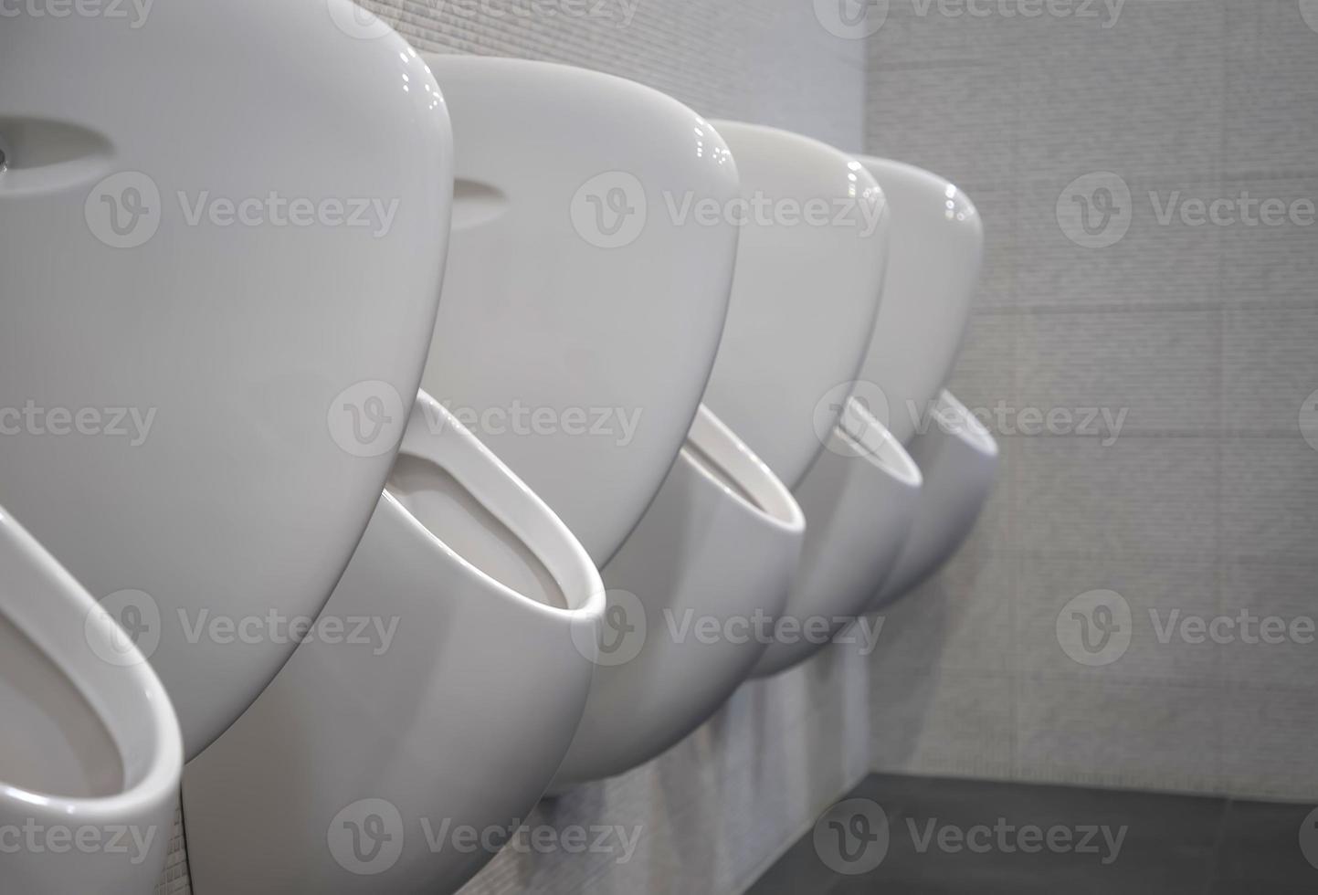 Closeup white urinals in men's bathroom, the design of white ceramic urinals for men in the toilet room. public men toilet room, WC. photo