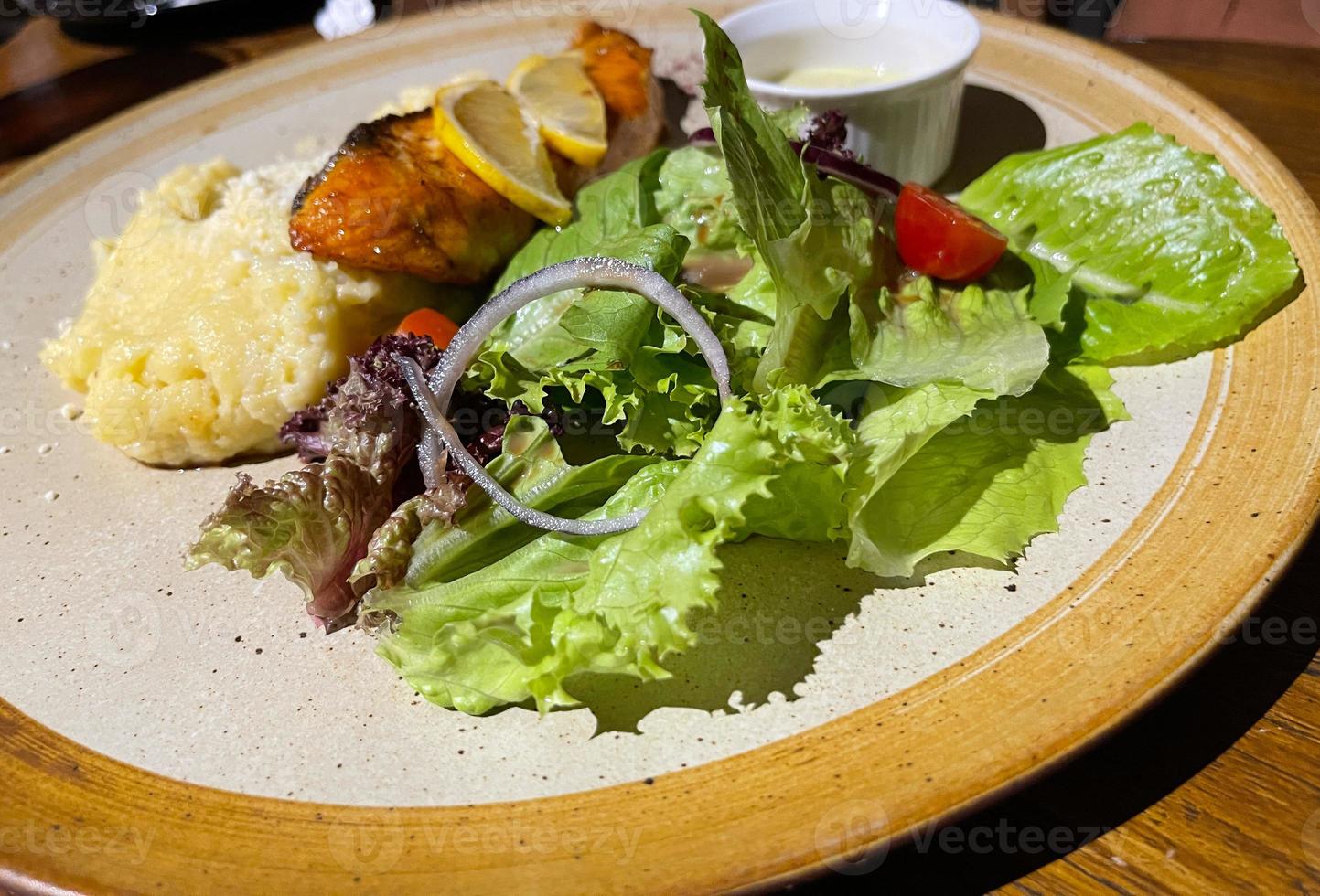 smoked grilled salmon fish served with salad and mash potatoes with