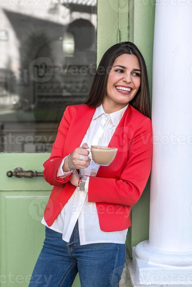 mujer de pie en la pared sosteniendo una taza en las manos foto