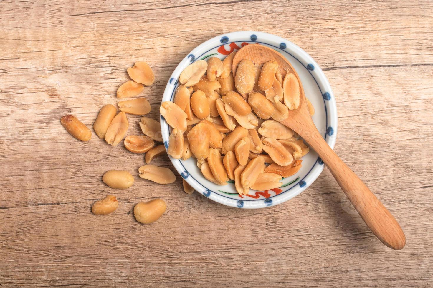 Peanuts in a cup on wooden background photo