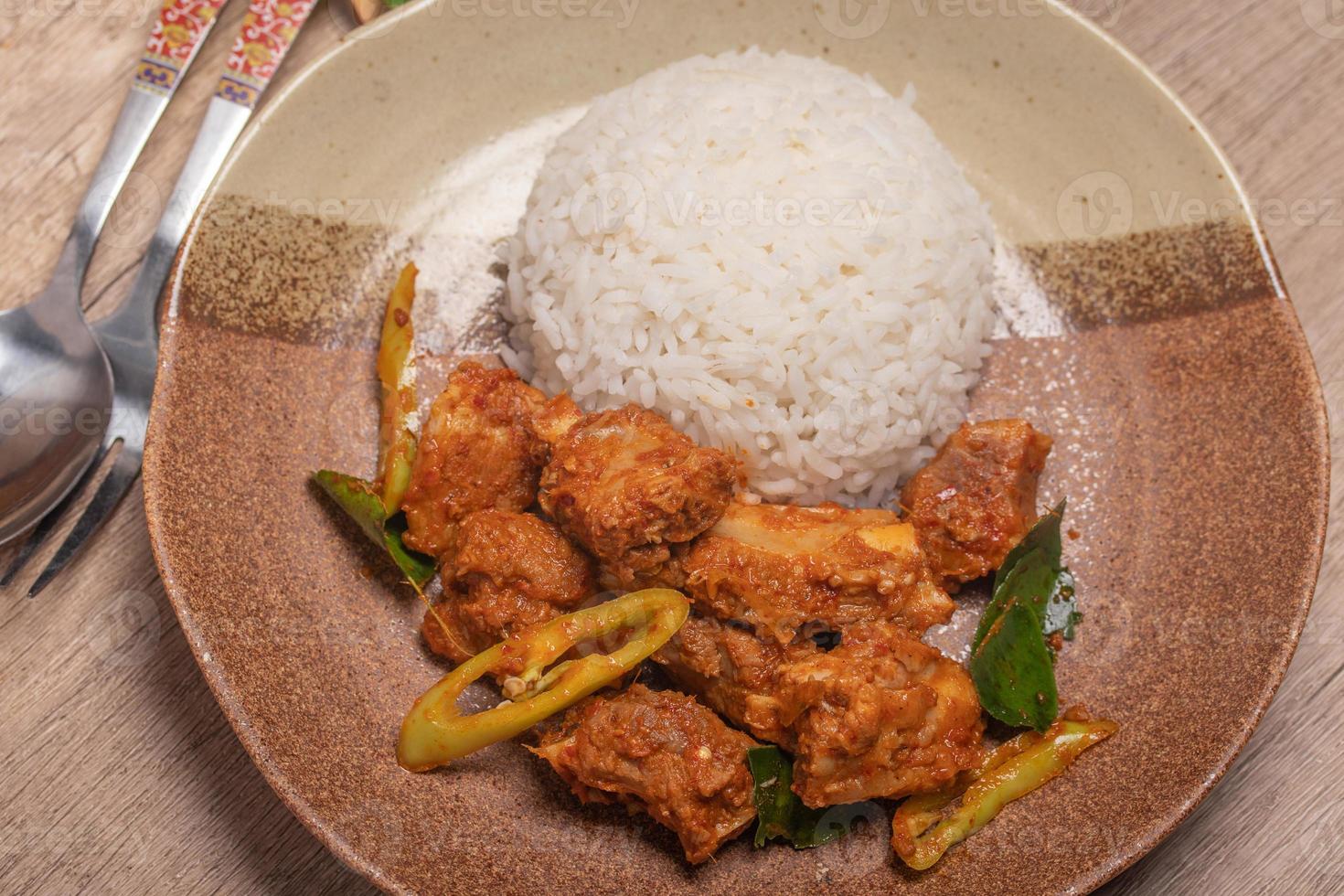 Stir-fried pork ribs with curry paste and steamed rice photo